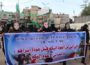 Hamas fighters march in Gaza with the faces of captured Israeli soldiers with a banner reading: 'Mother and father, I will not return to you before Palestinian prisoners return home.' (Photo: via Twitter)